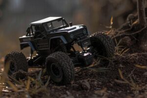 Detailed close-up of an RC off-road toy car navigating rugged outdoor terrain.